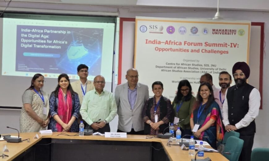 Group of participants standing in front of presentation screens at India–Africa Forum Summit–IV, with slide on India–Africa digital partnership and event banner.